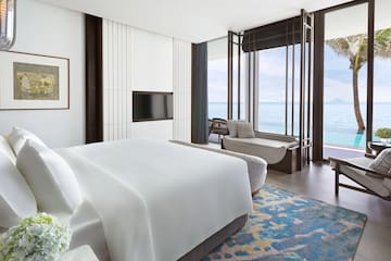 a room with a bed and a couch and a window