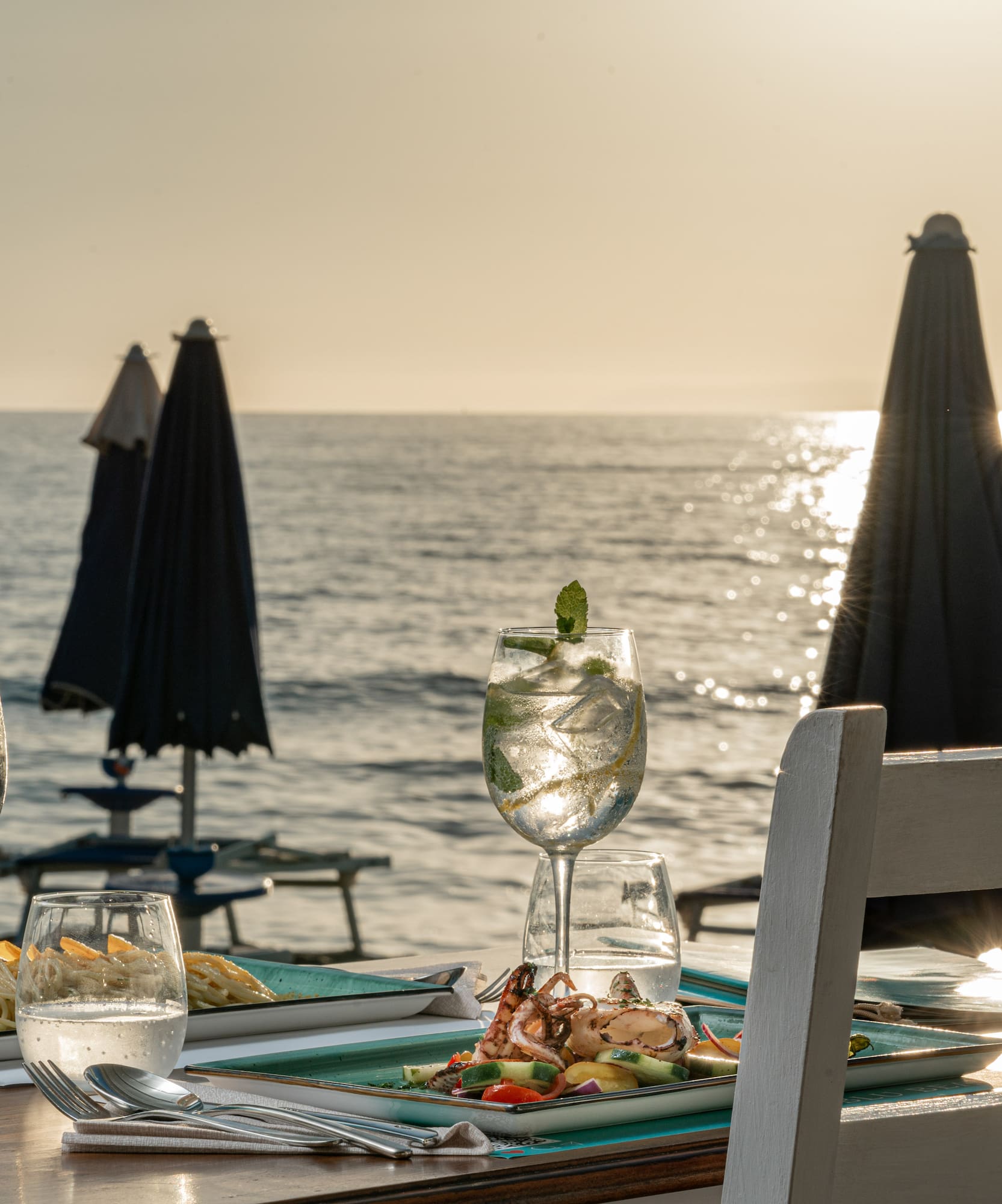 a table with food on it and a beach in the background