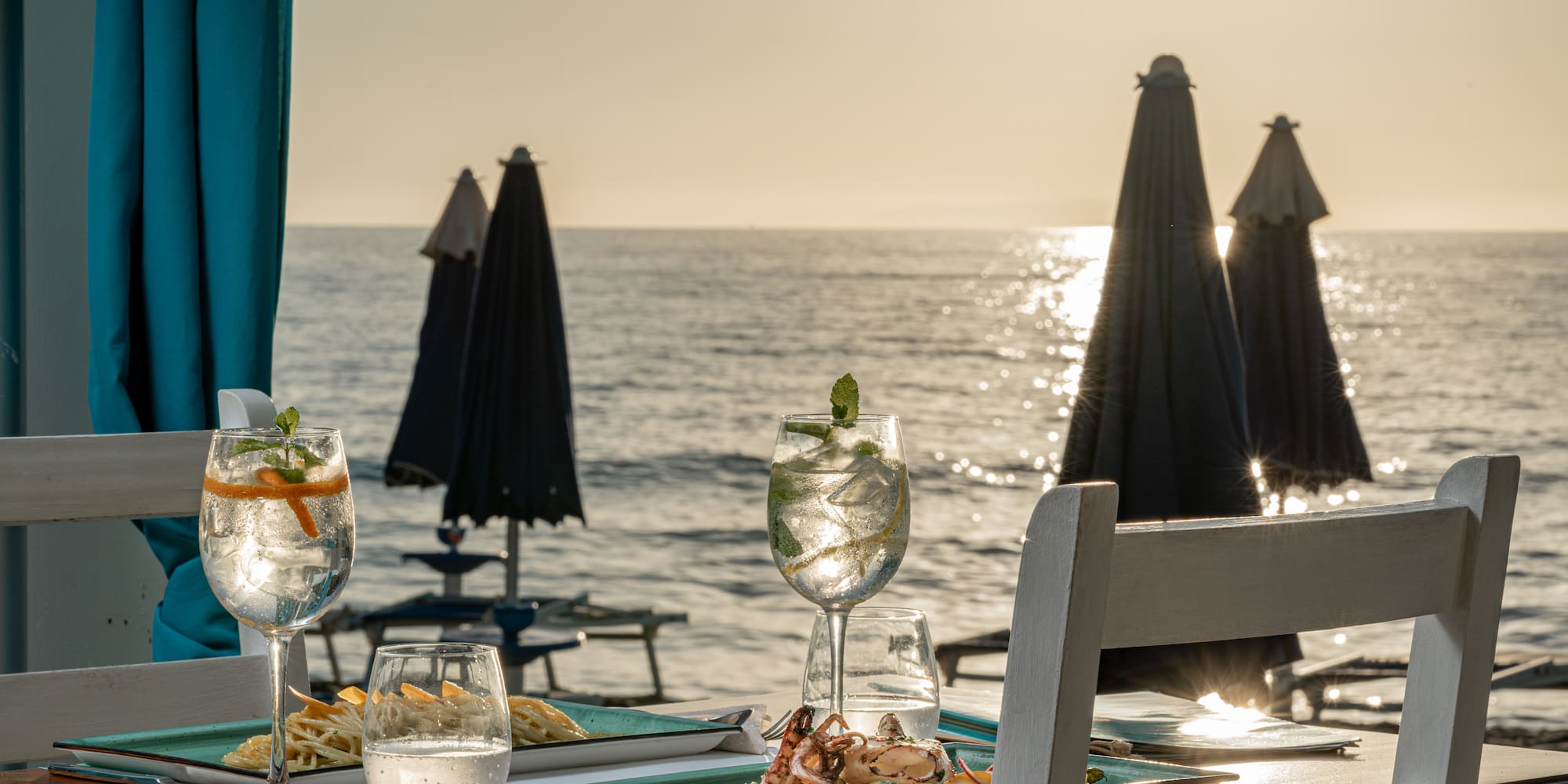 a table with food on it and a beach in the background