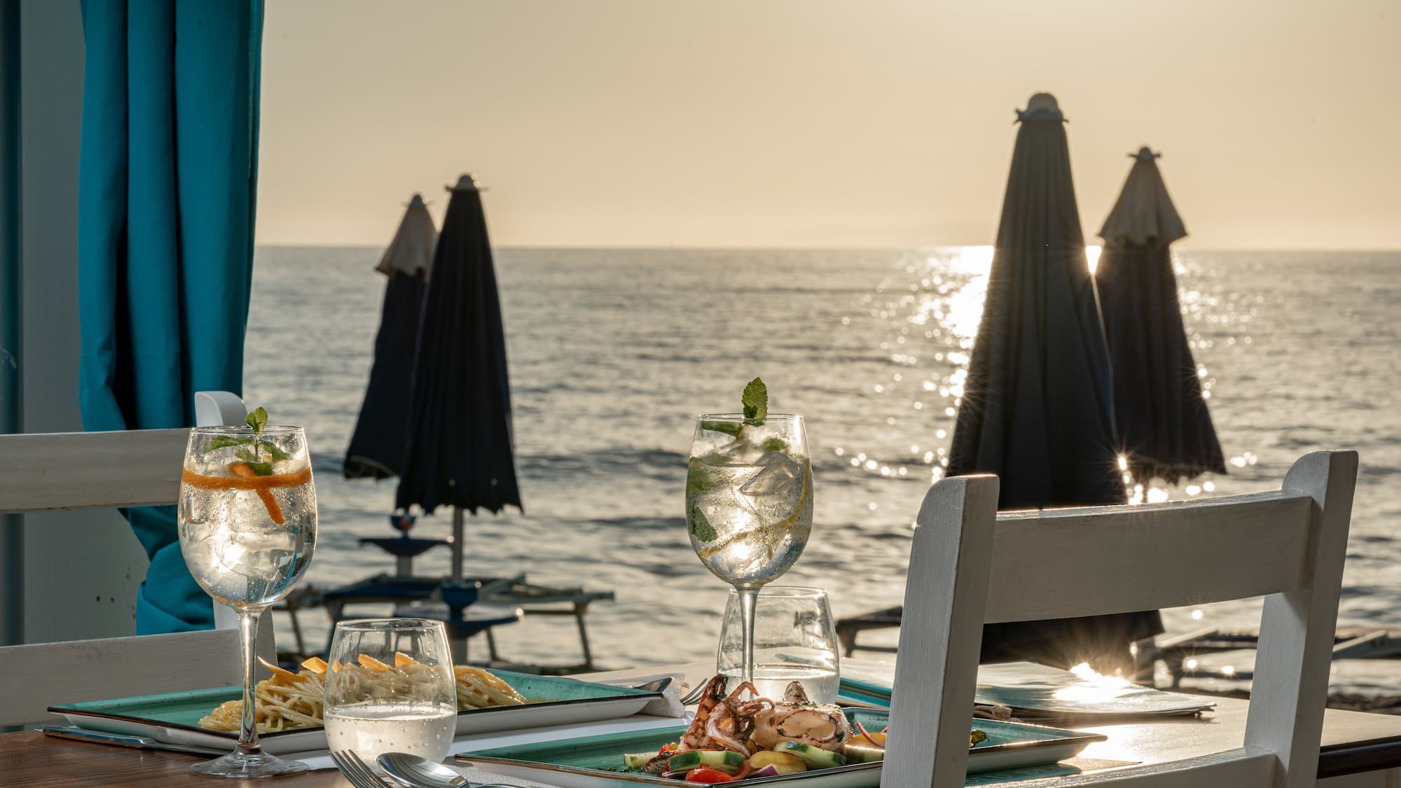 a table with food on it and a beach in the background