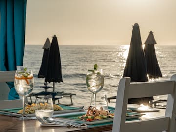 a table with food on it and a beach in the background