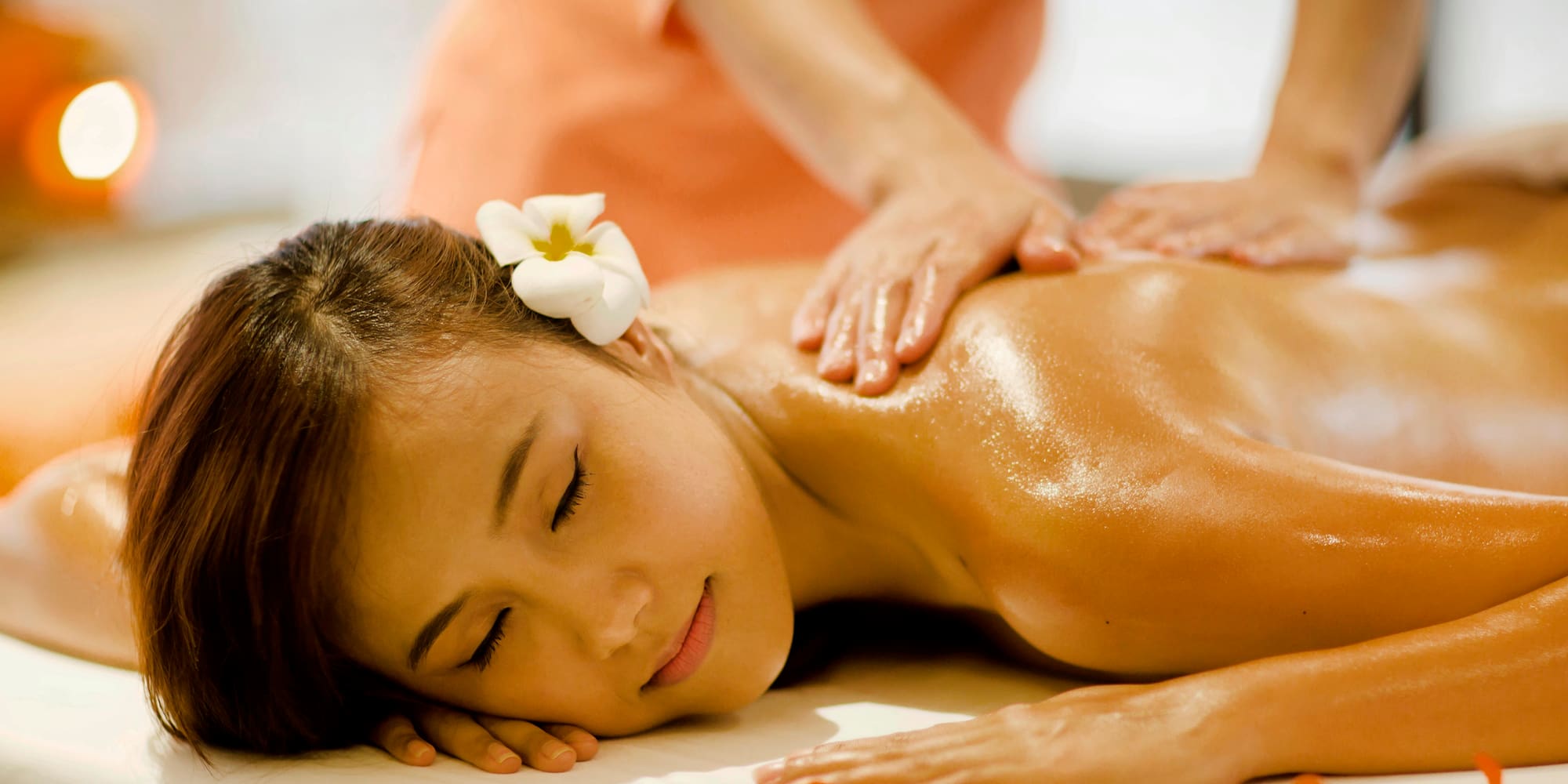 a woman lying down on a table with a flower in her hair