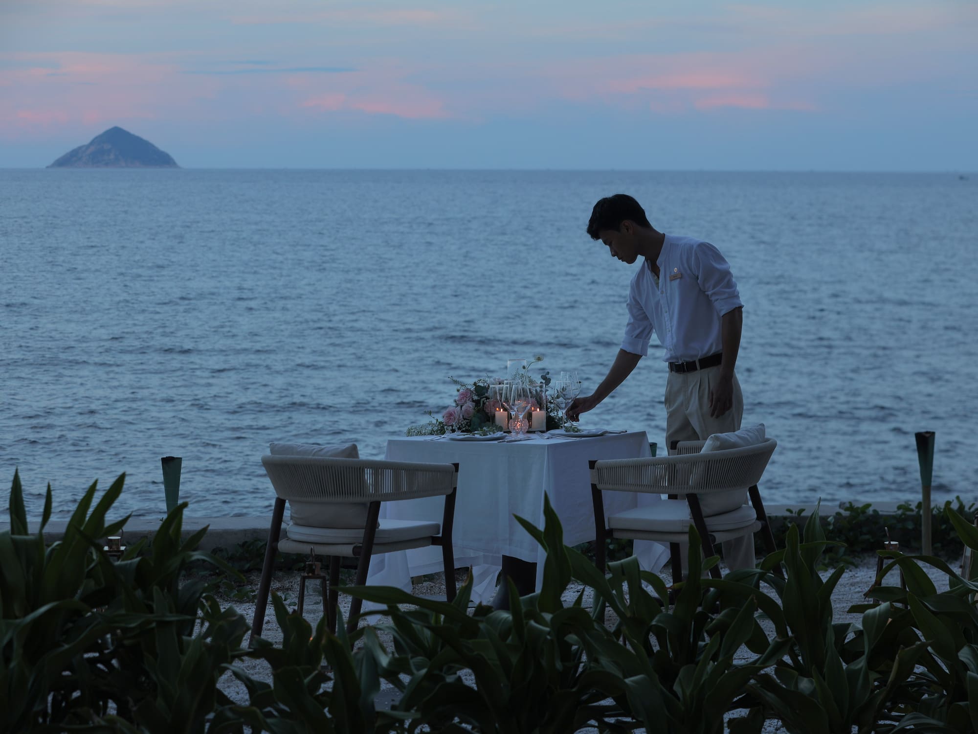 a man setting a table on a beach