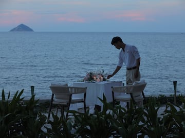 a man setting a table on a beach