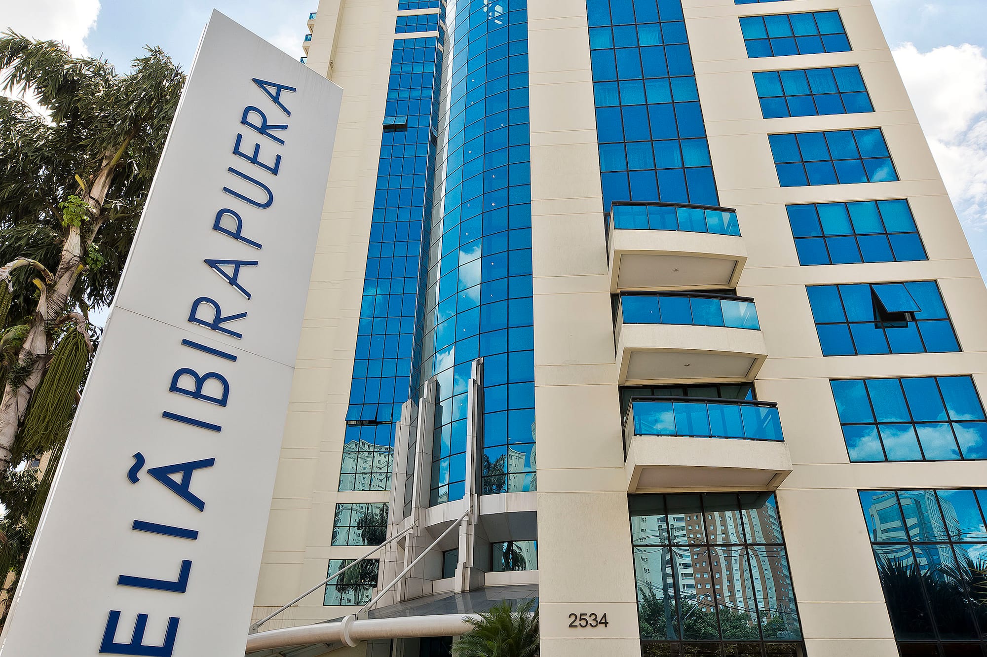 Meliá Ibirapuera hotel, modern cream building with blue reflective windows and sign.