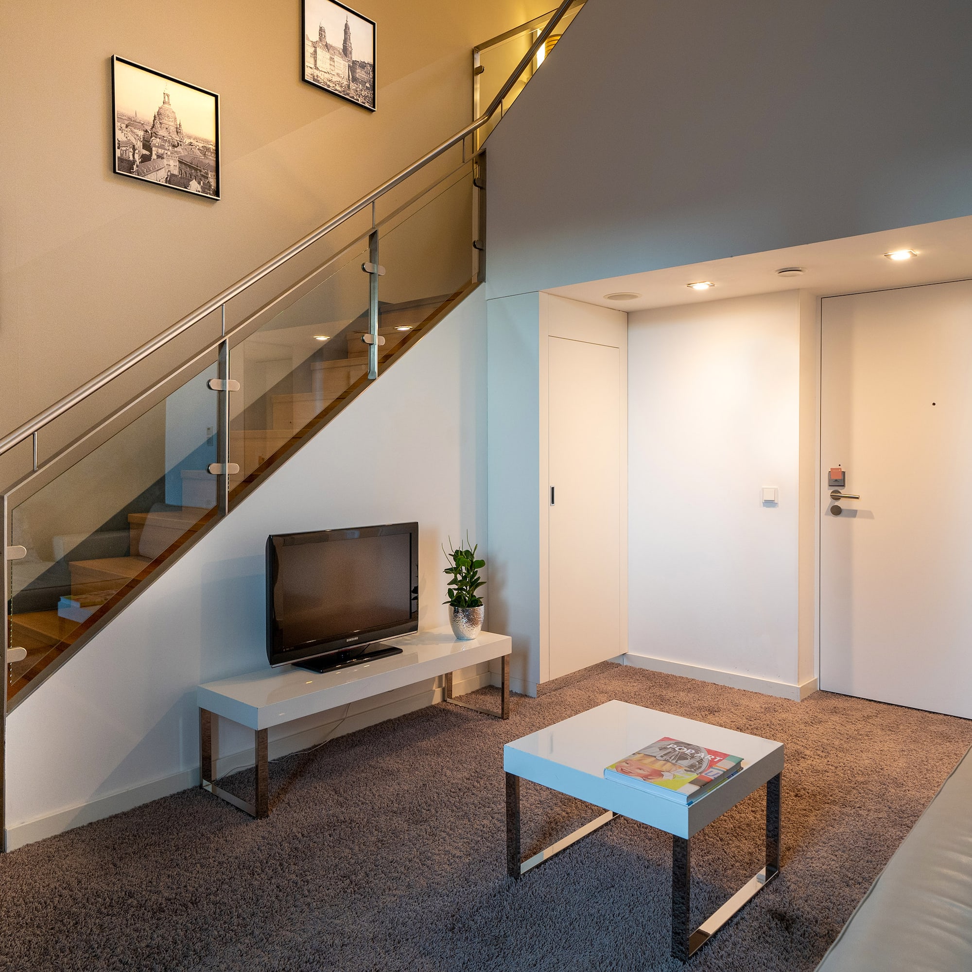 a living room with a staircase and a tv