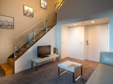 a living room with a staircase and a tv