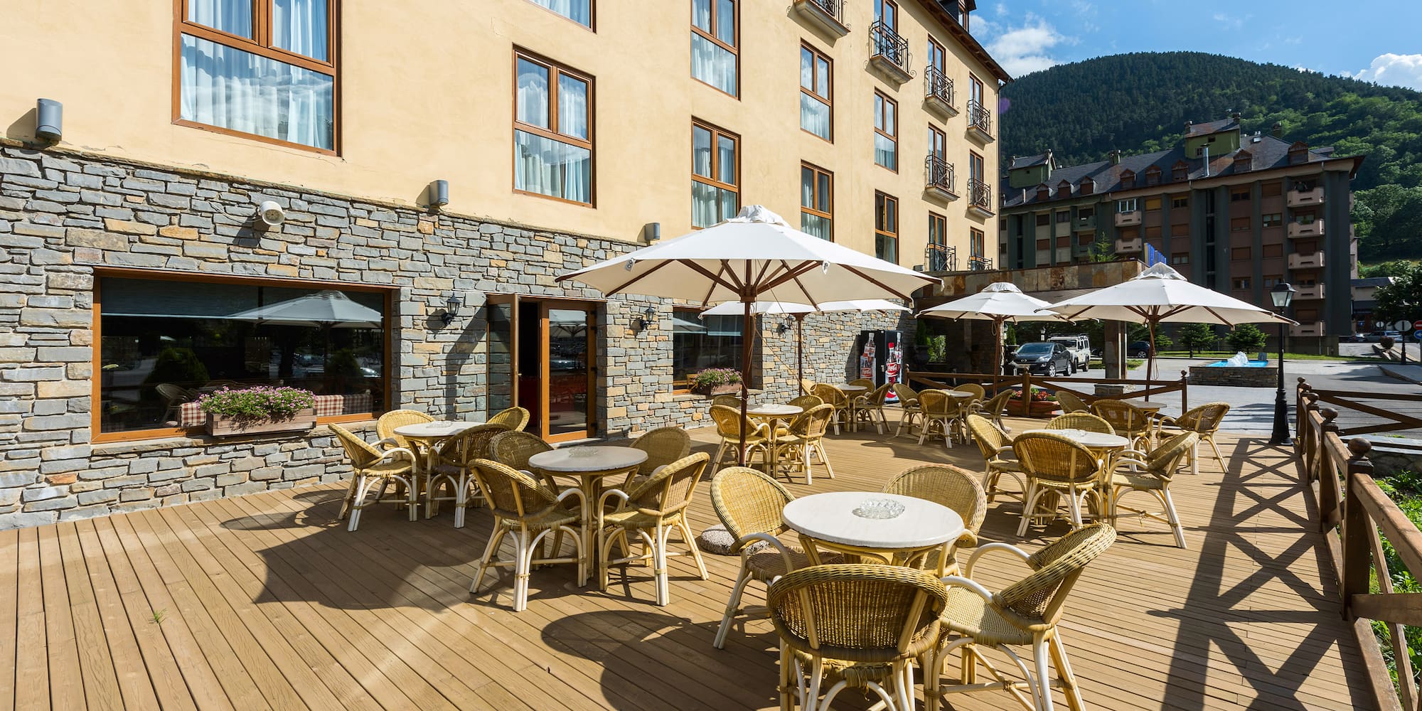 a patio with chairs and umbrellas outside of a building