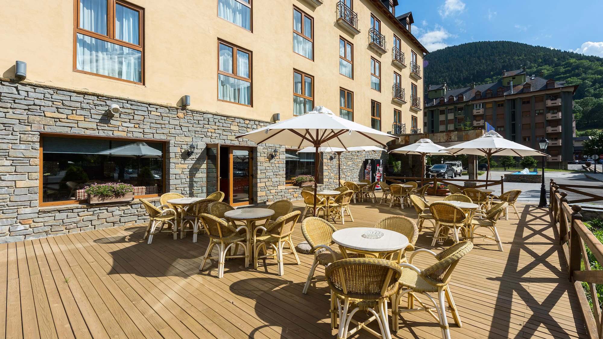 a patio with chairs and umbrellas outside of a building