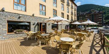 a patio with chairs and umbrellas outside of a building