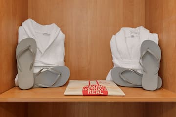 a pair of white robes and flip flops on a shelf