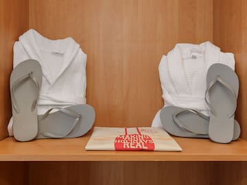 a pair of white robes and flip flops on a shelf