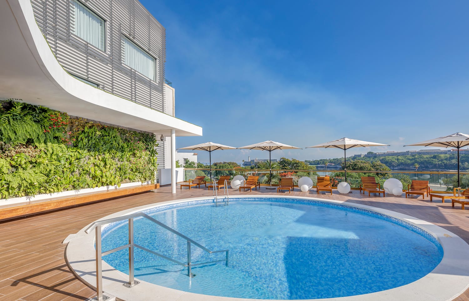a swimming pool with umbrellas and chairs on a deck
