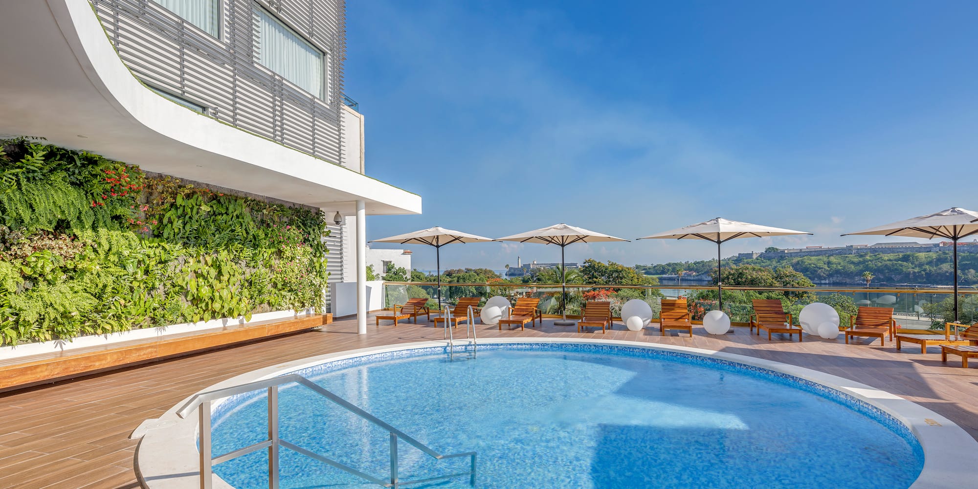 a swimming pool with umbrellas and chairs on a deck