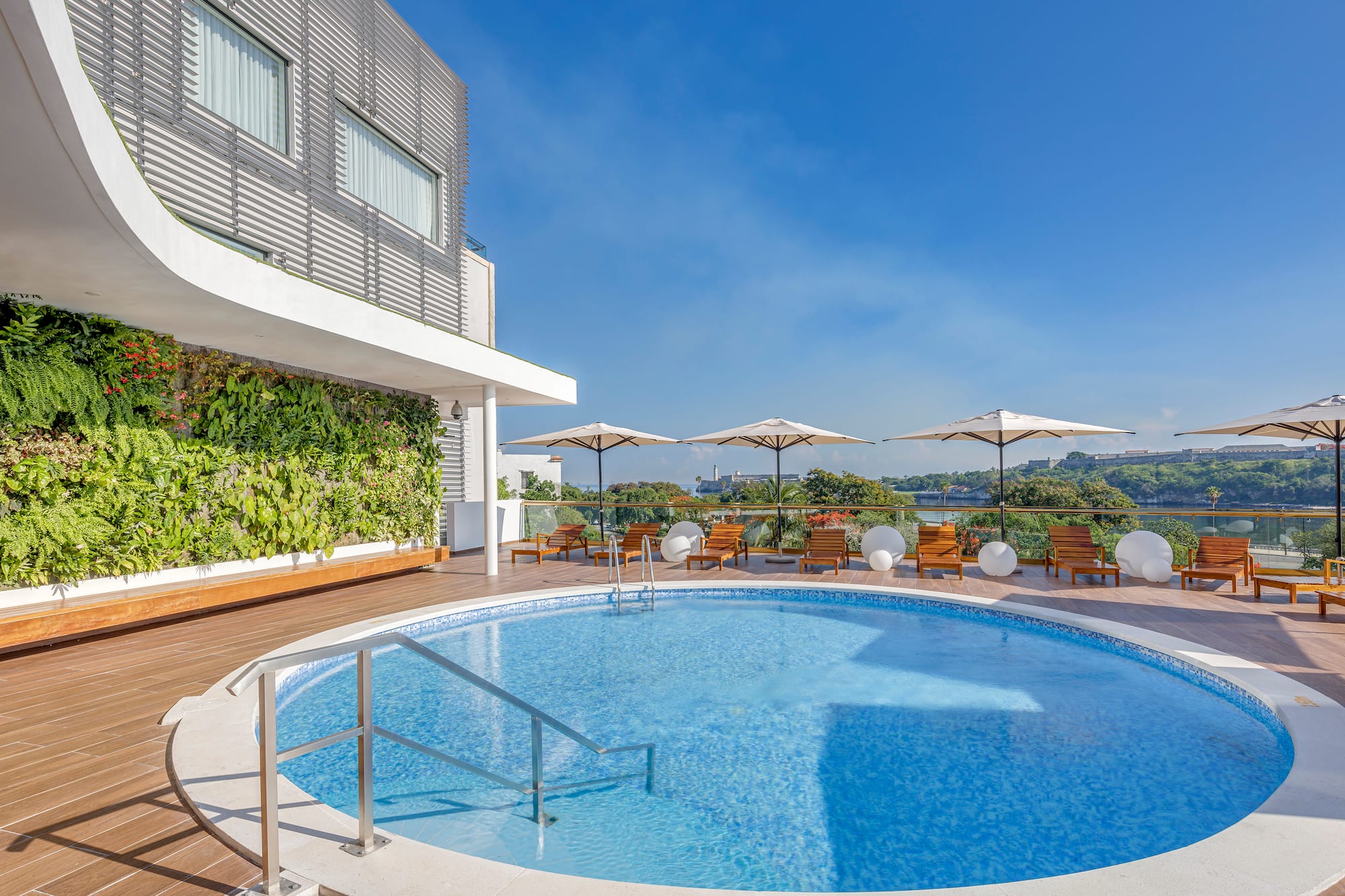a swimming pool with umbrellas and chairs on a deck