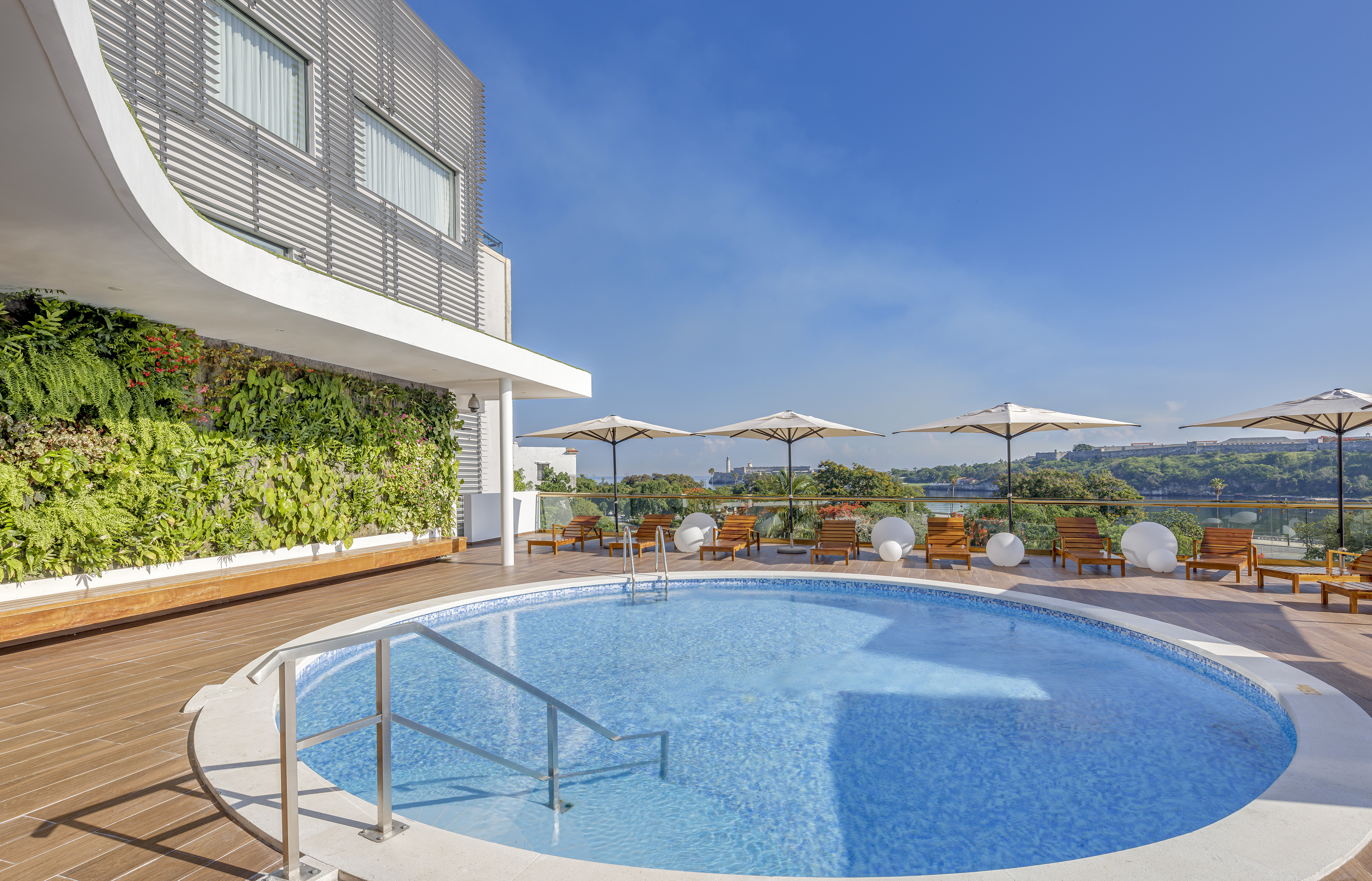 a swimming pool with umbrellas and chairs on a deck