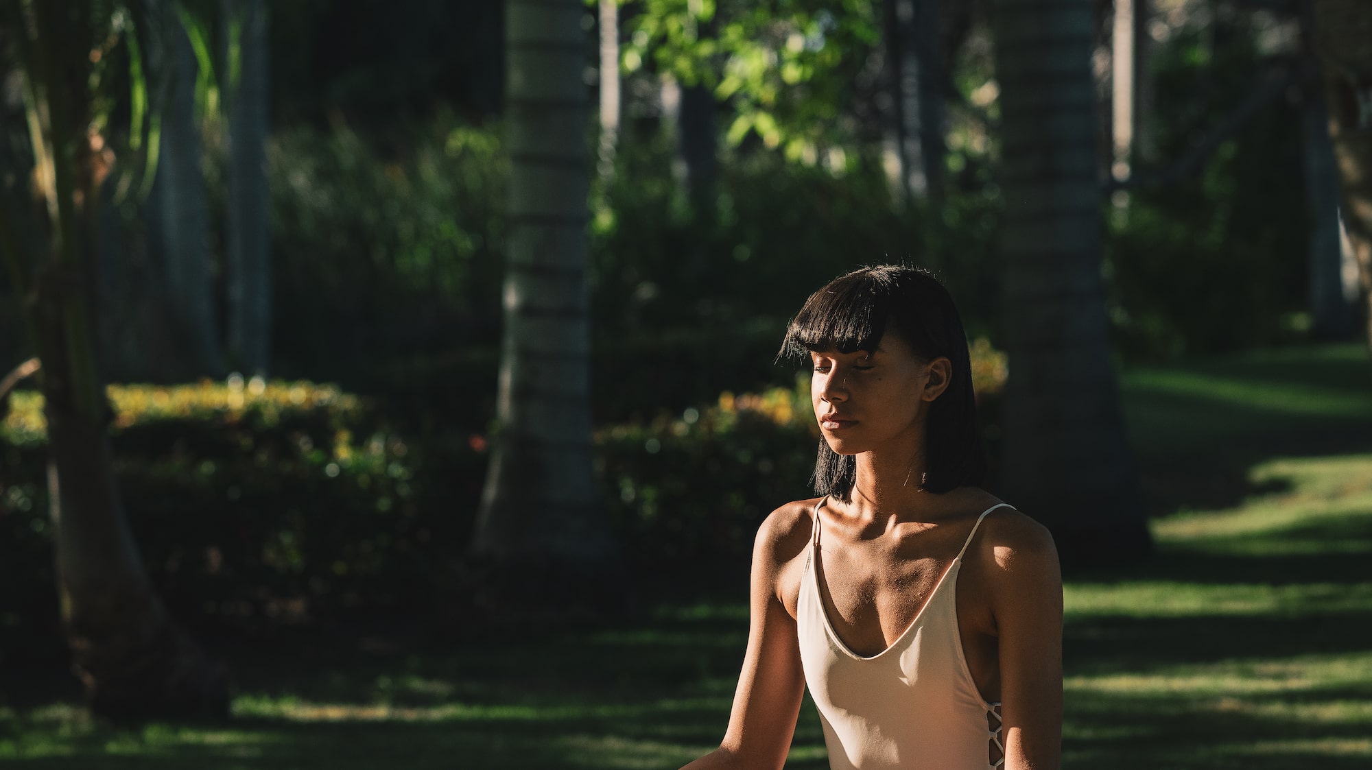 a woman sitting on a mat in the grass