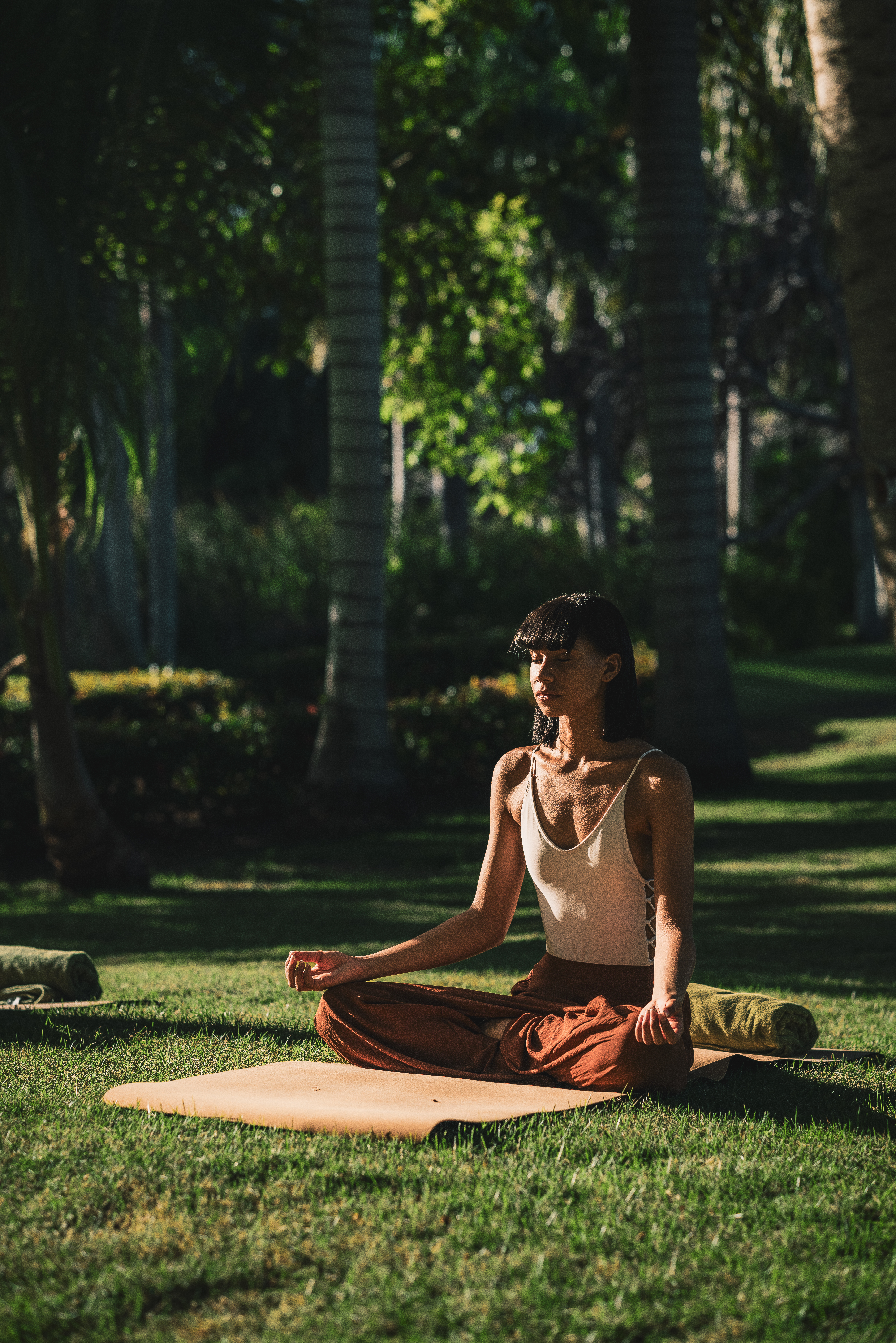 a woman sitting on a mat in the grass