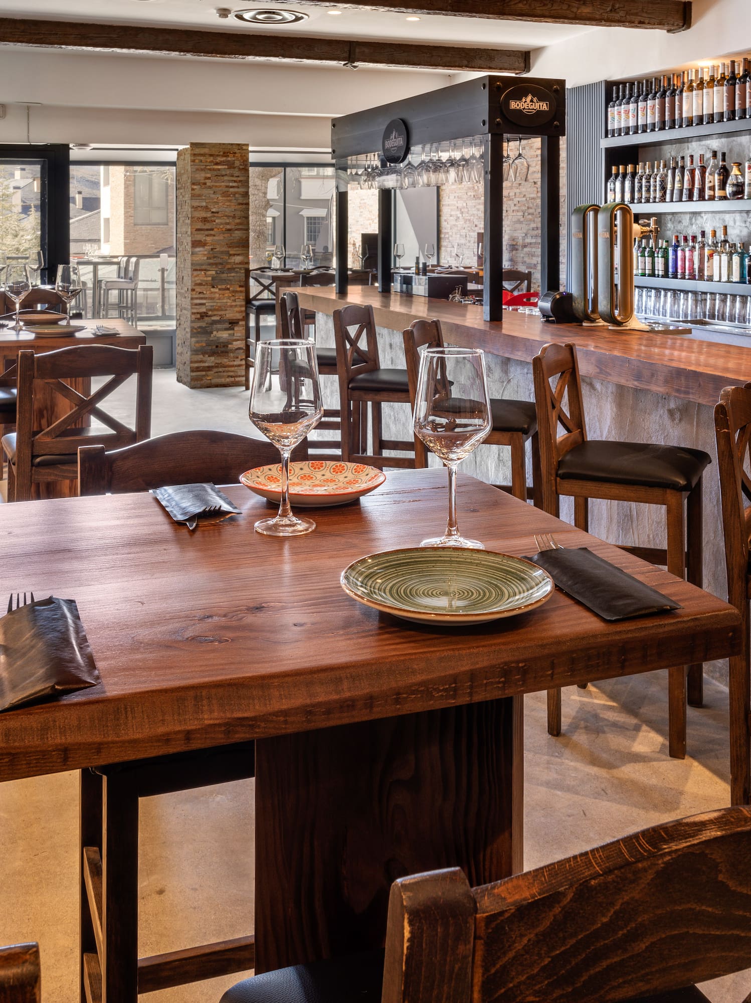 a restaurant with a bar and wine glasses