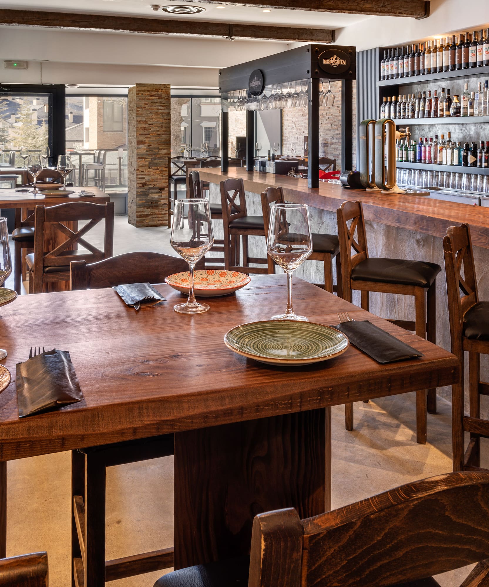 a restaurant with a bar and wine glasses