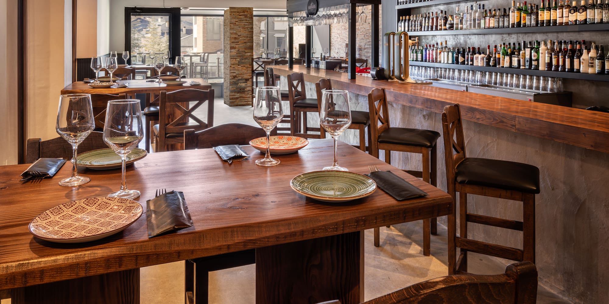 a restaurant with a bar and wine glasses