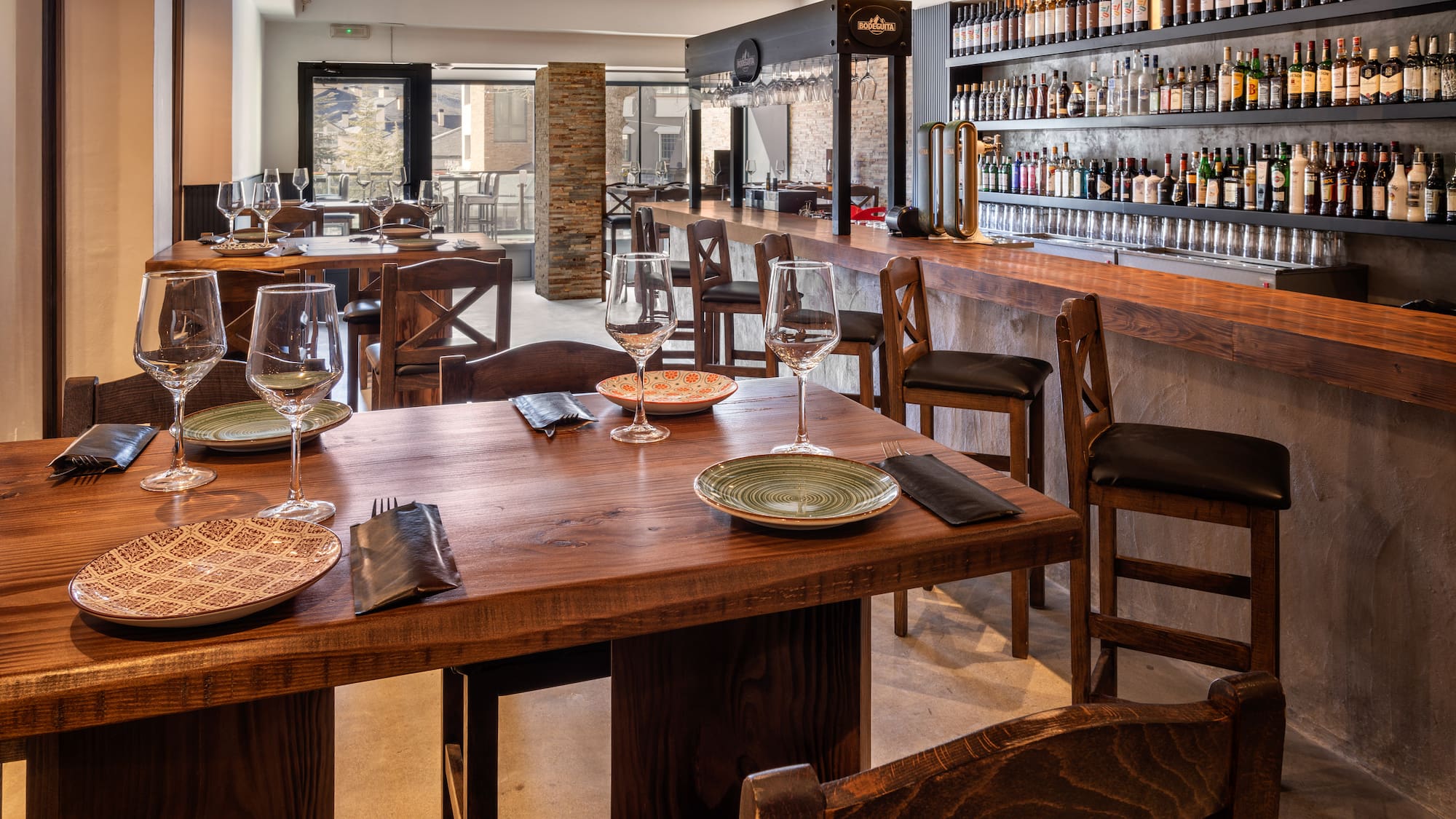 a restaurant with a bar and wine glasses