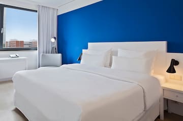 a bed with white sheets and a blue wall