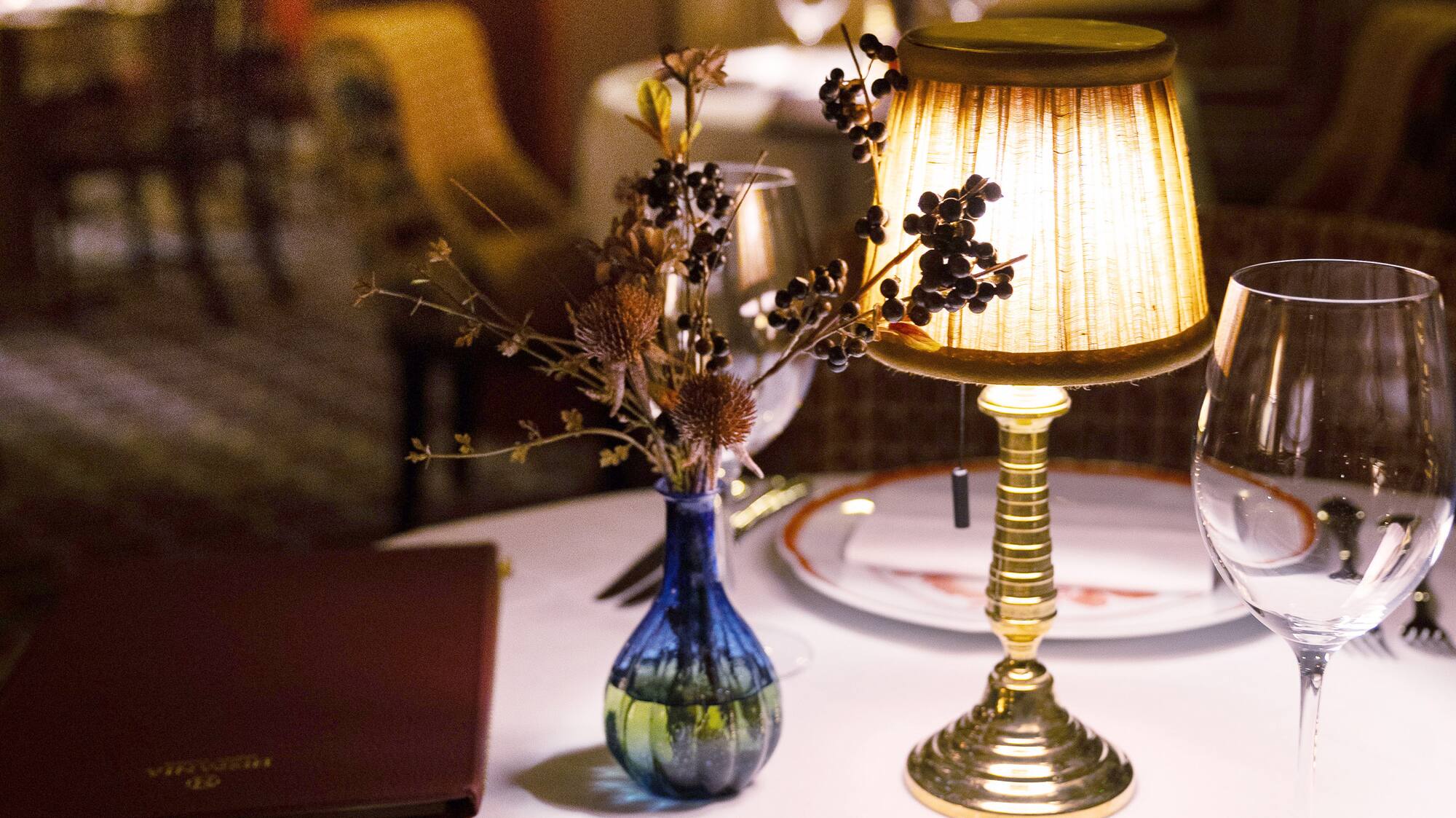 a table with a lamp and glasses