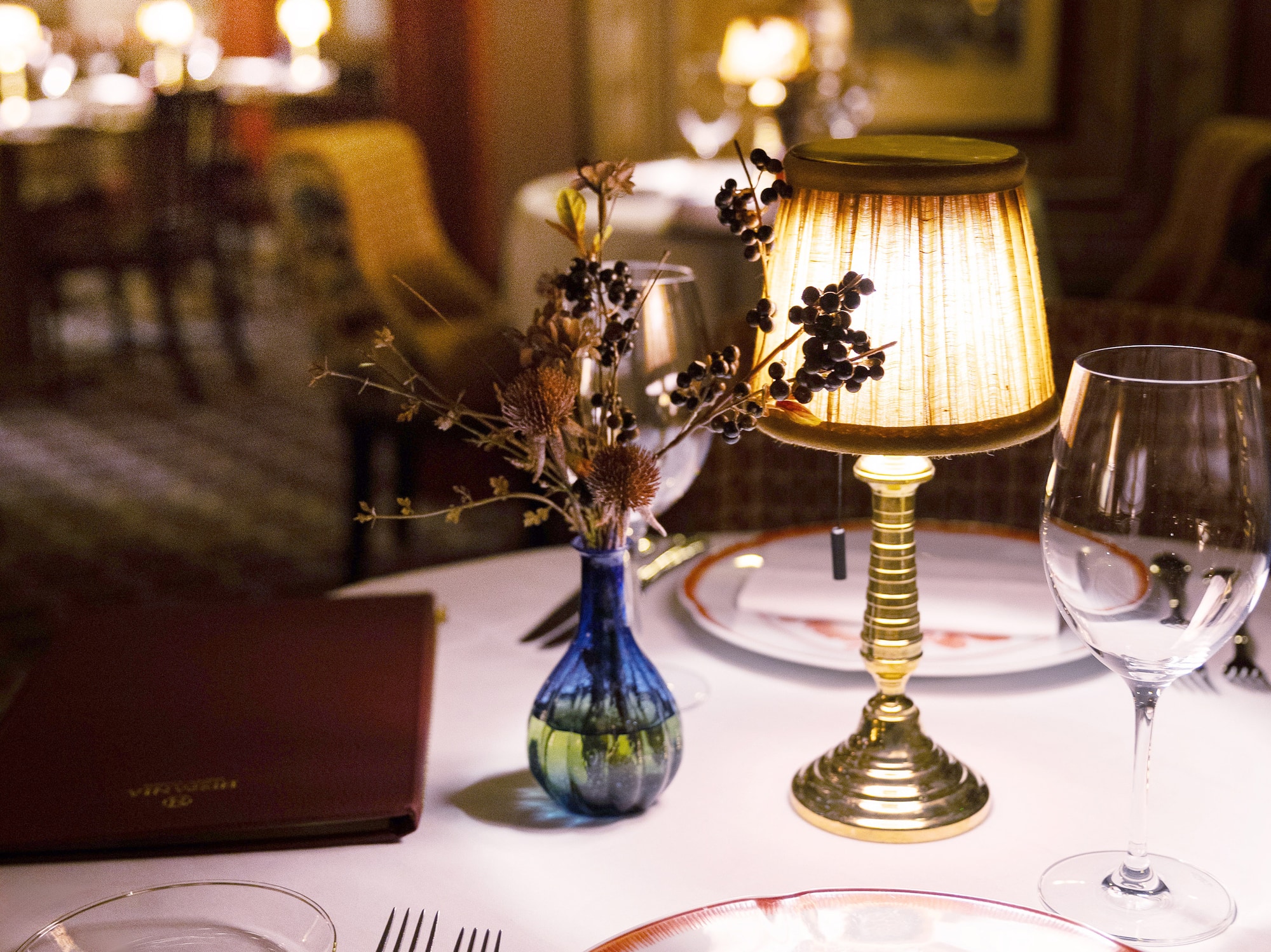 a table with a lamp and glasses