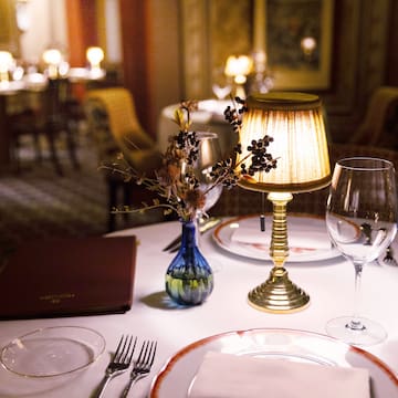 a table with a lamp and glasses