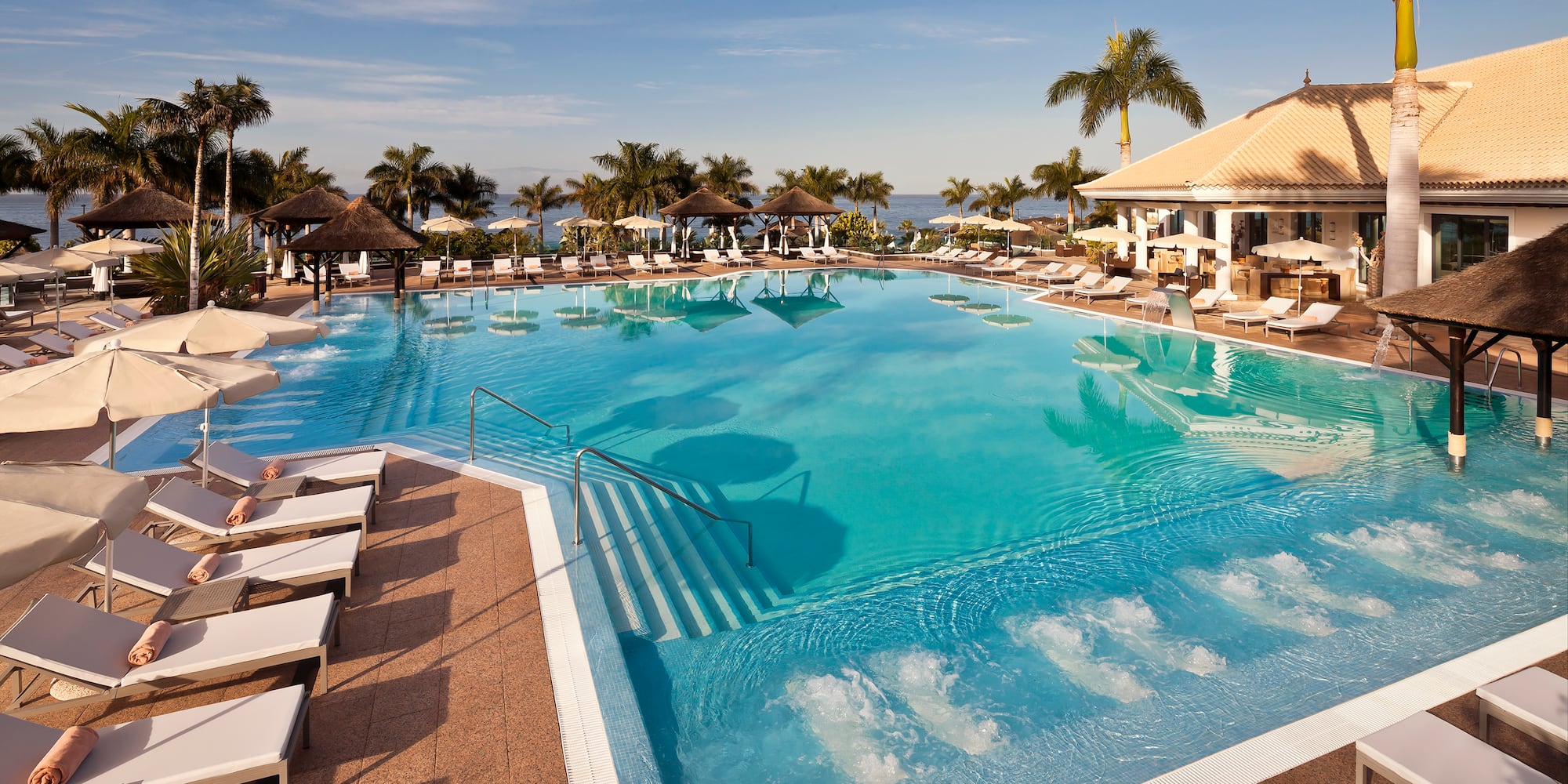 a pool with chairs and a building
