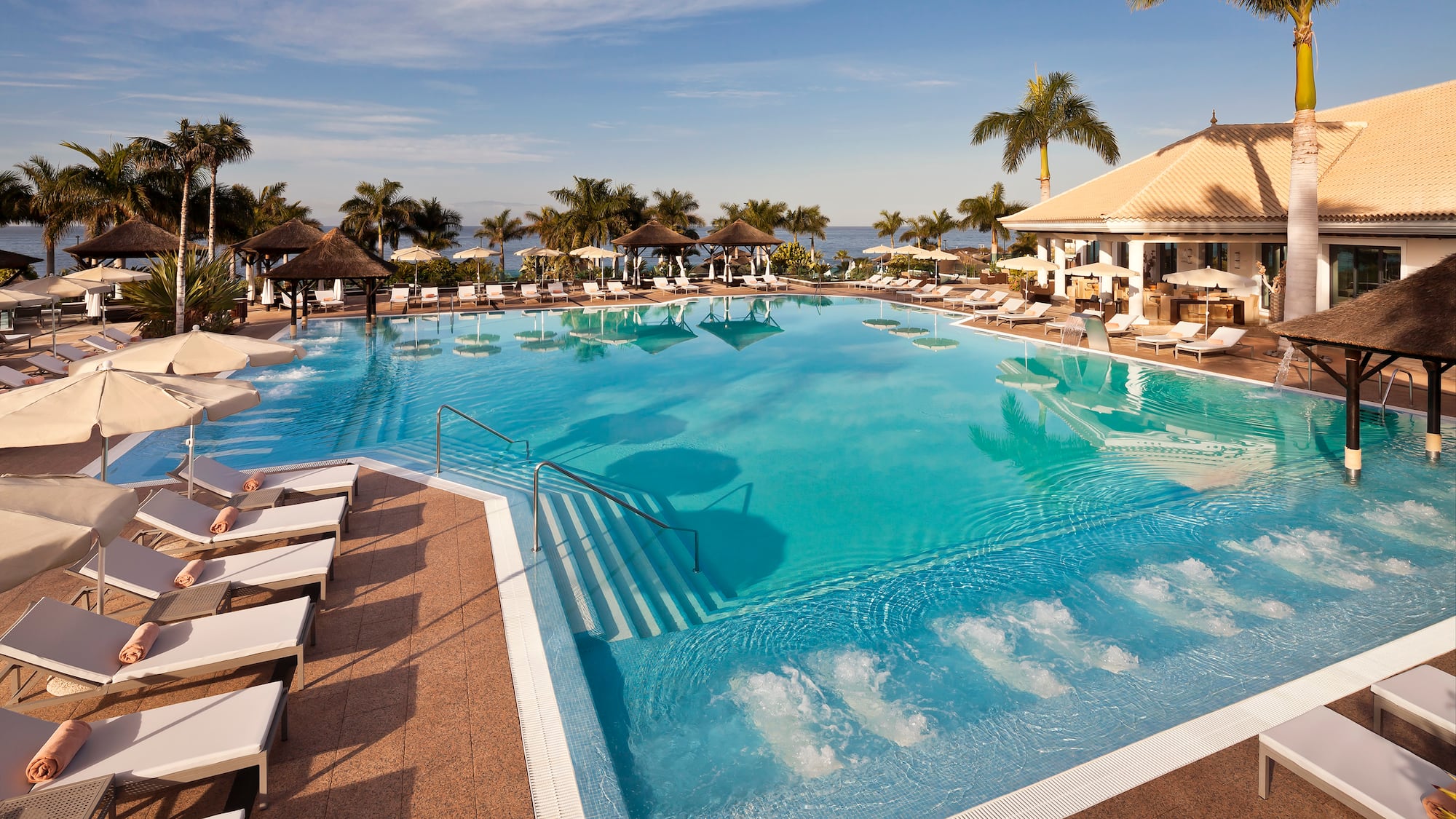 a pool with chairs and a building