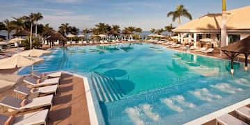 a pool with chairs and a building