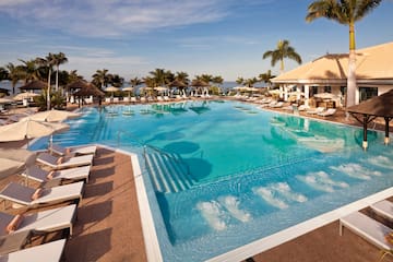 a pool with chairs and a building