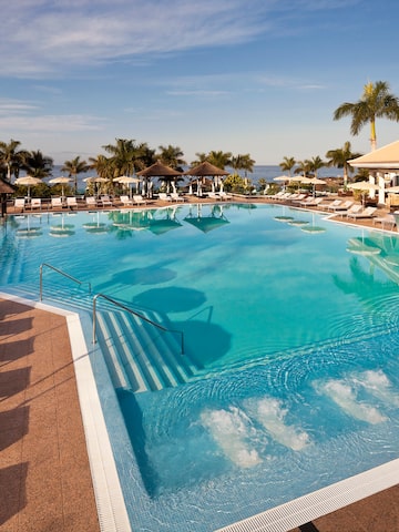 a pool with chairs and a building