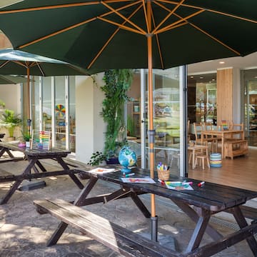 a picnic table and umbrellas outside of a building