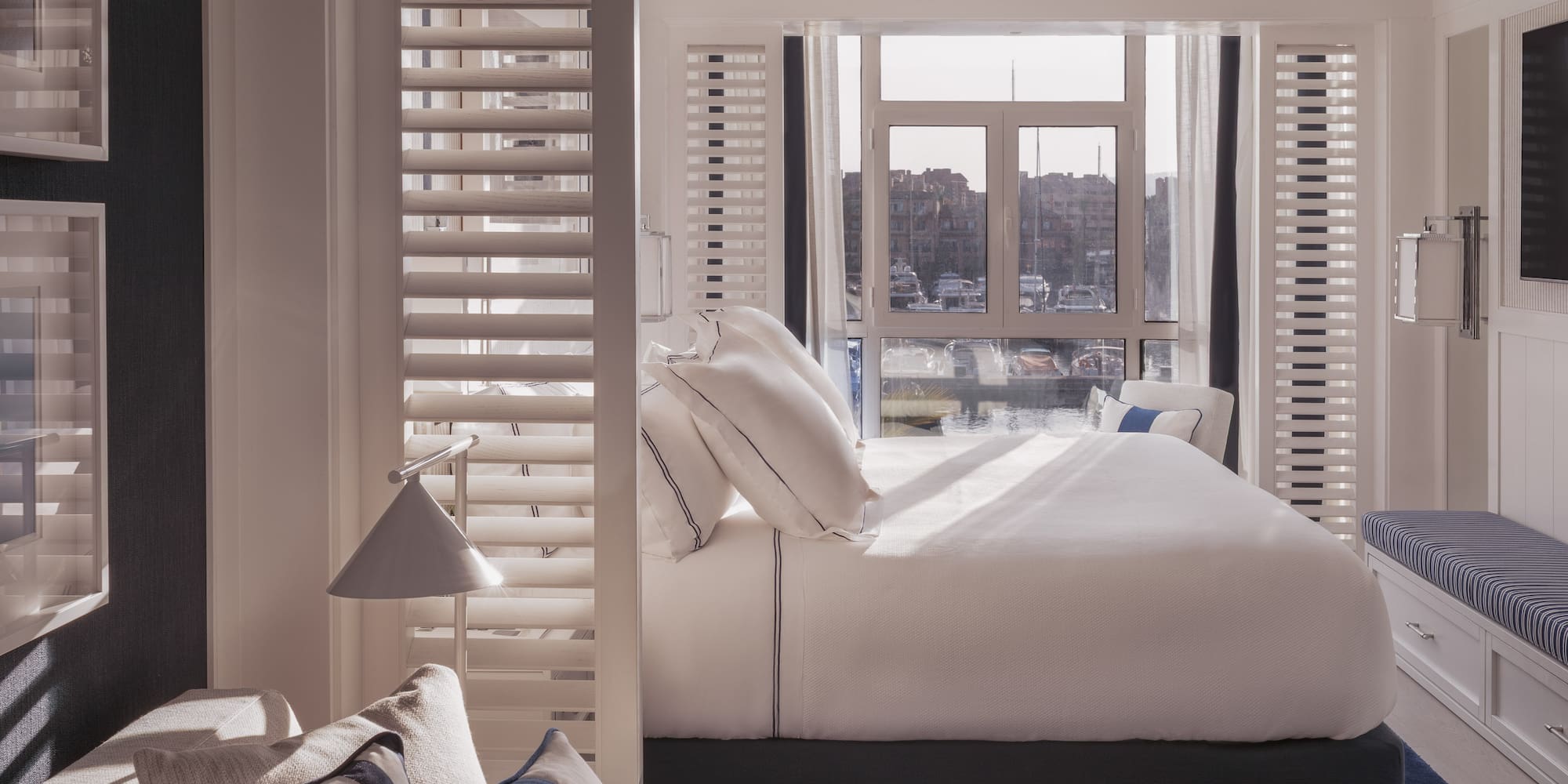 a bed with pillows in a room with a window