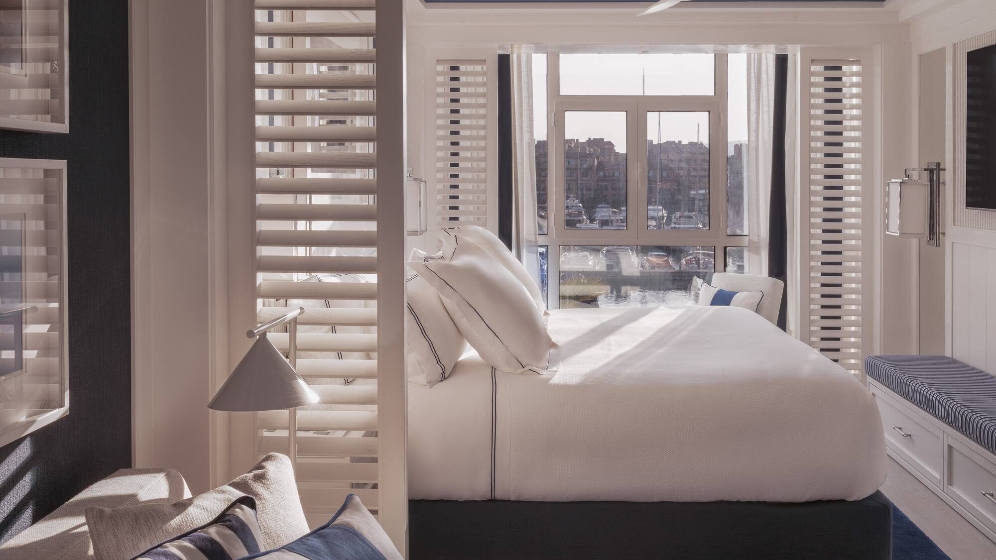 a bed with pillows in a room with a window