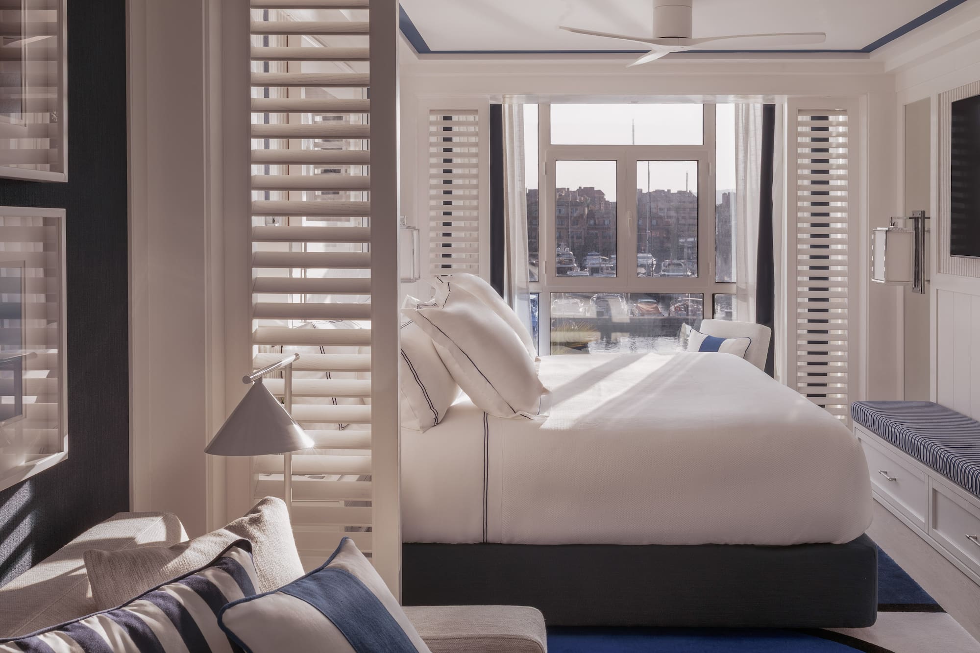 a bed with pillows in a room with a window