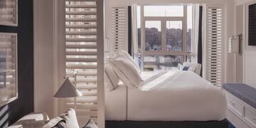 a bed with pillows in a room with a window