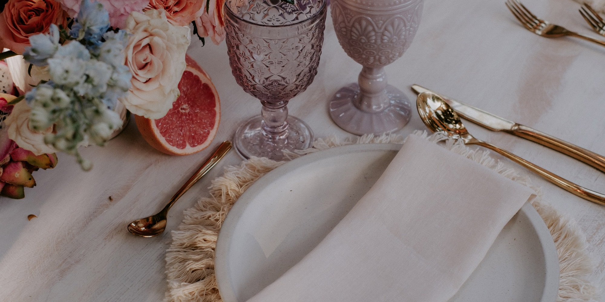 a table with plates and glasses and flowers