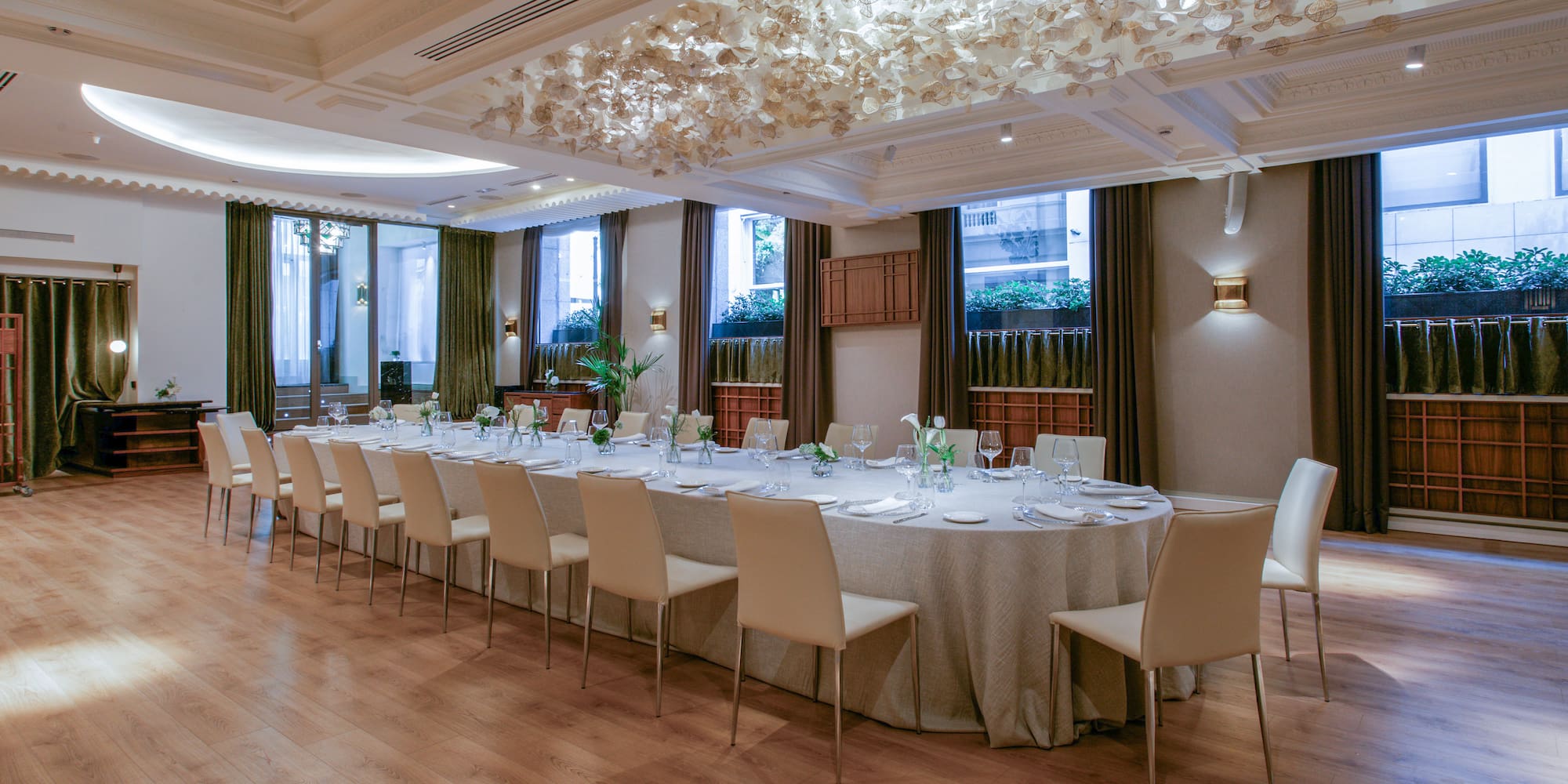 a large round table with white chairs and a table set up