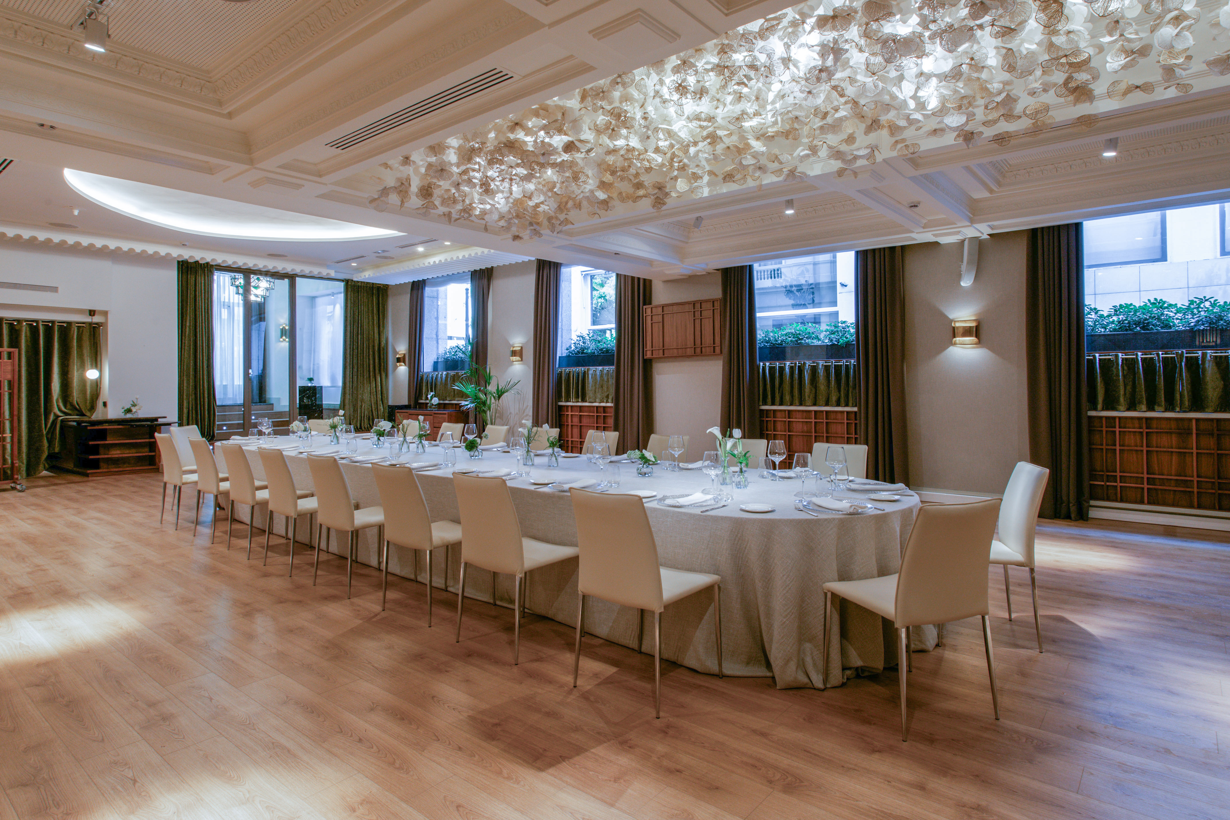 Luxury private dining room with long table, chairs, and ornate ceiling.