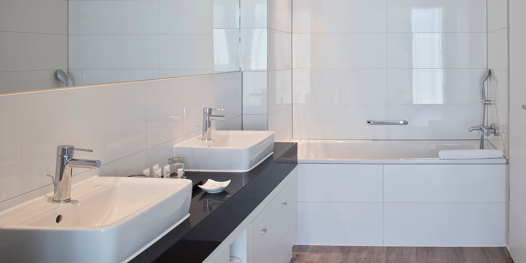 a bathroom with white tile walls and sinks