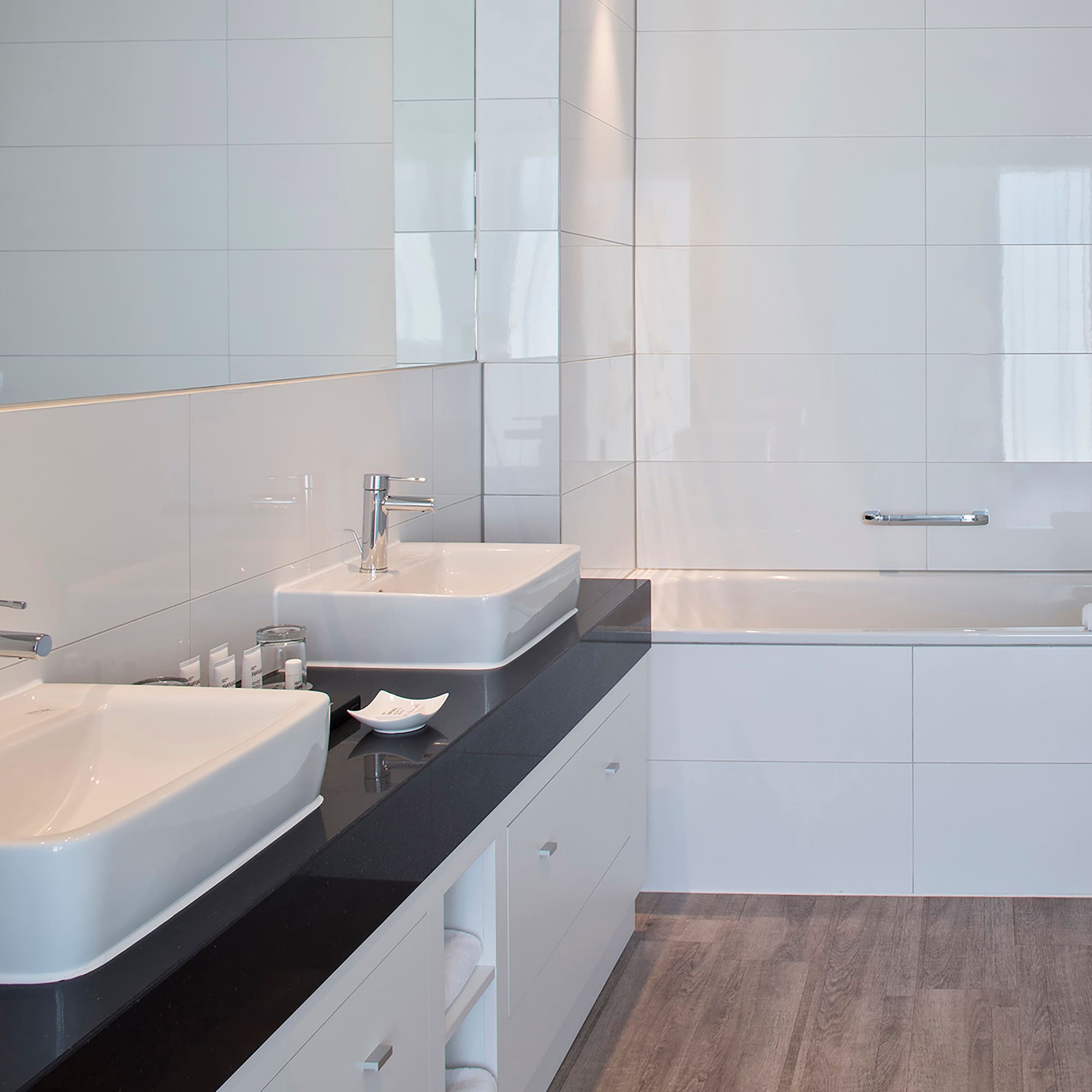a bathroom with white tile walls and sinks