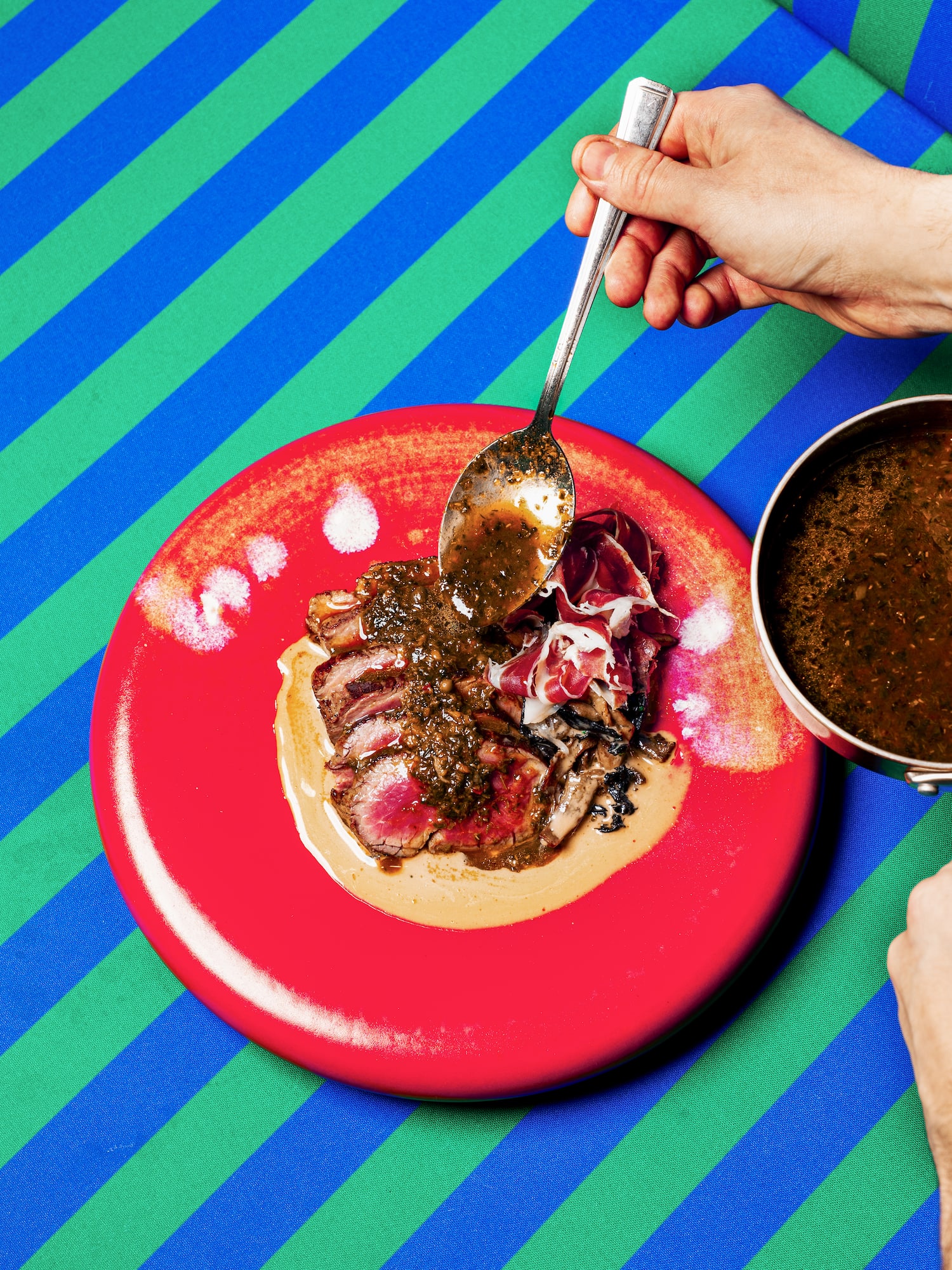 a person holding a spoon over food
