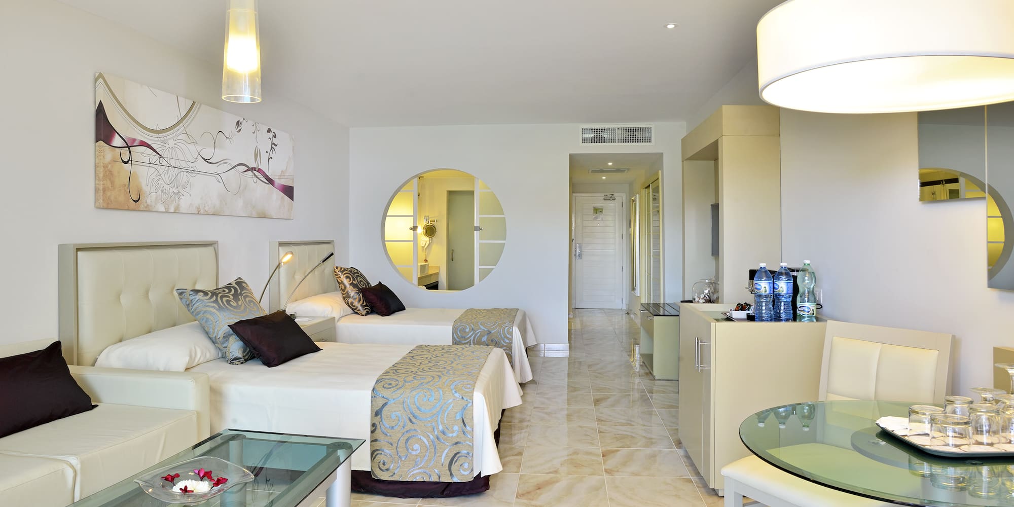 a room with two beds and a round mirror