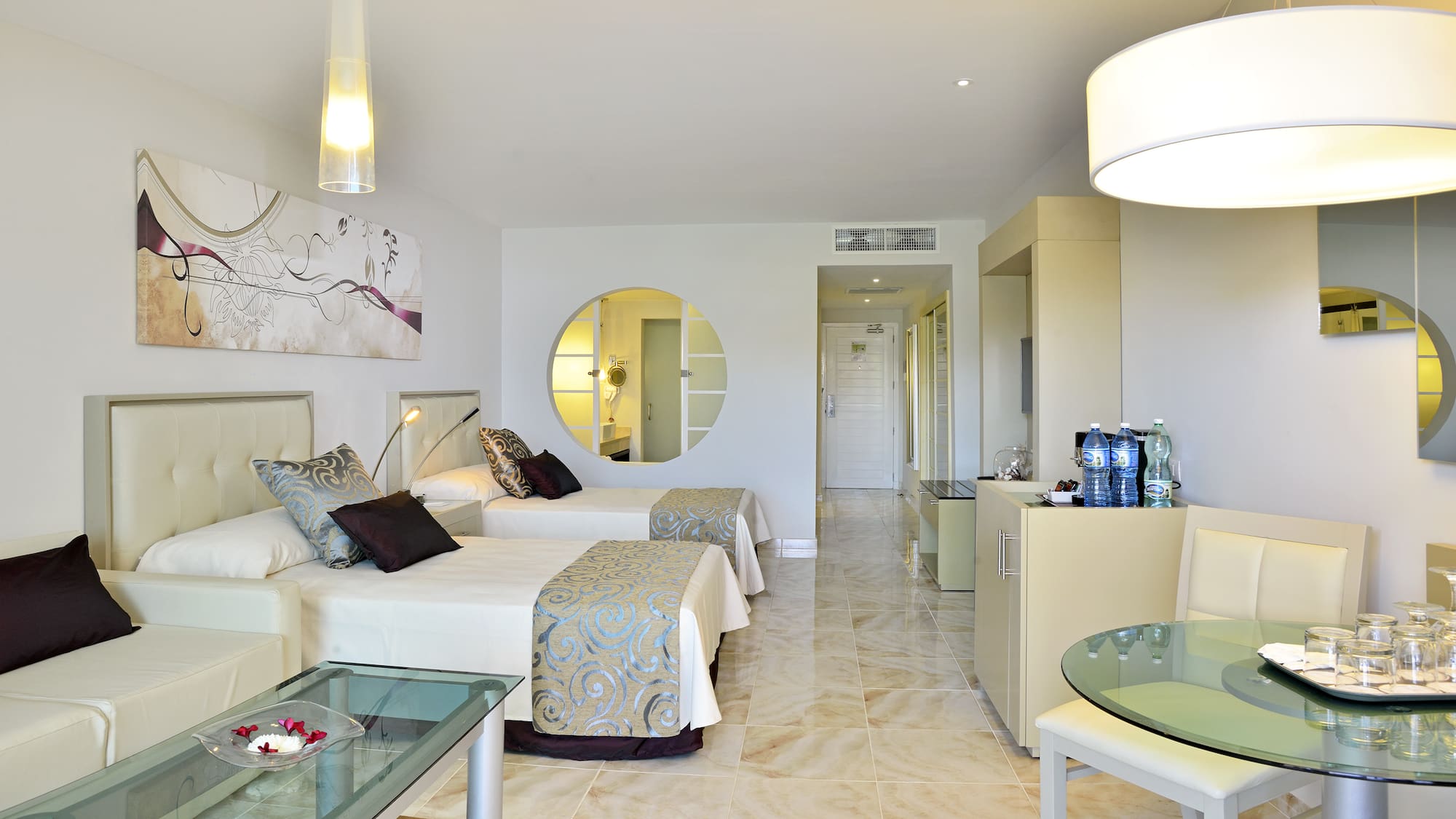 a room with two beds and a round mirror