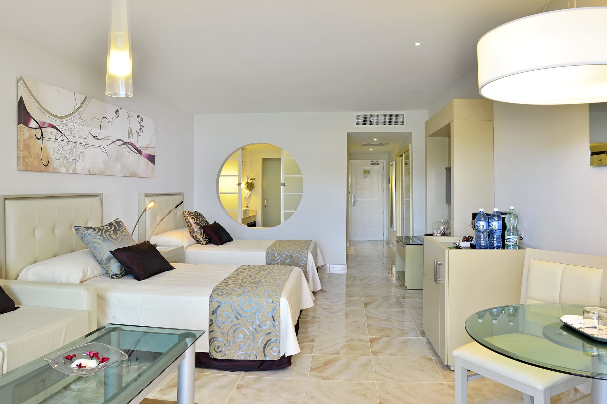 a room with two beds and a round mirror