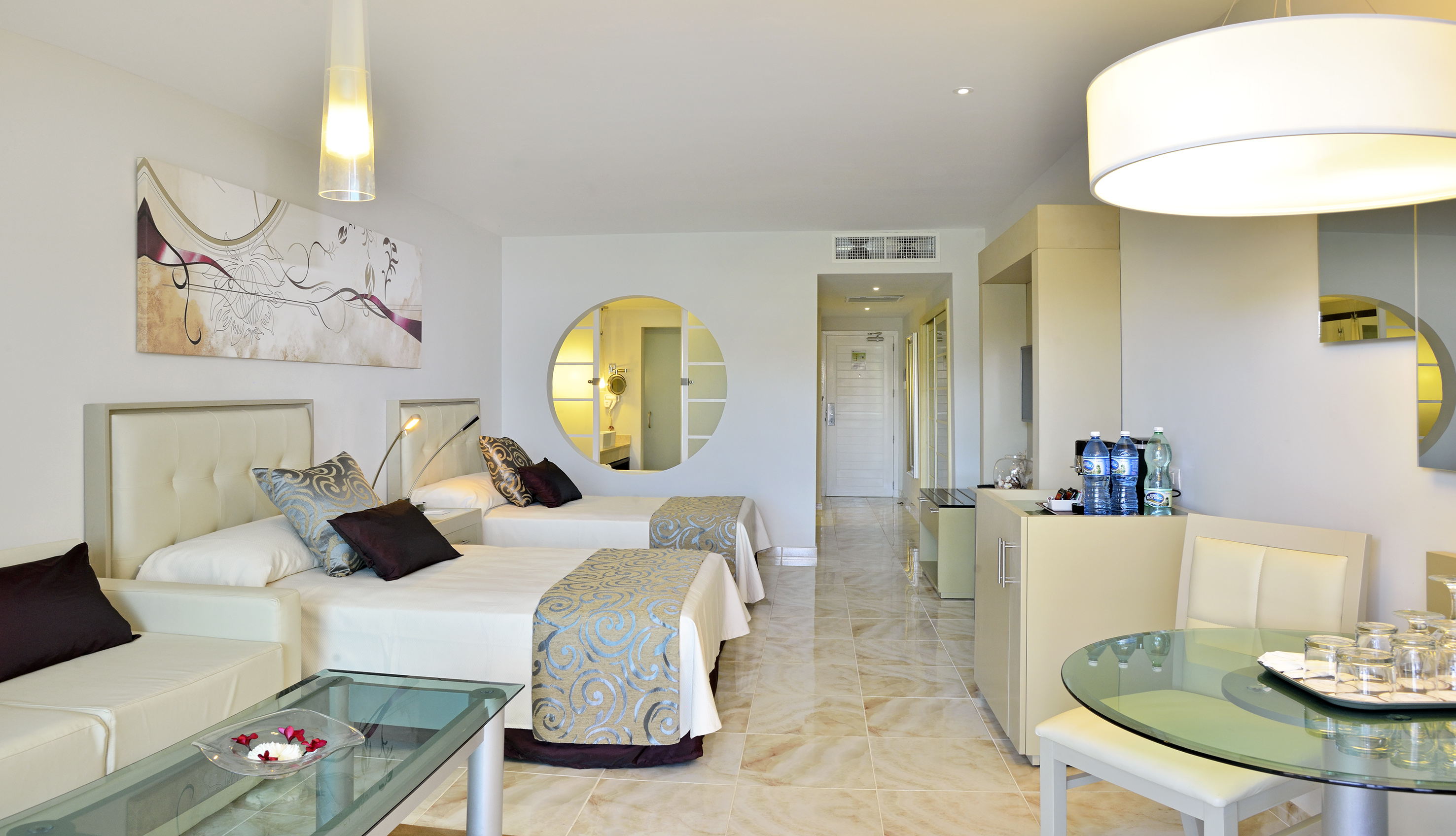 a room with two beds and a round mirror